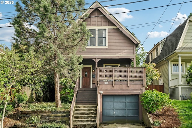 view of front of property with a garage, covered porch, stairs, and fence