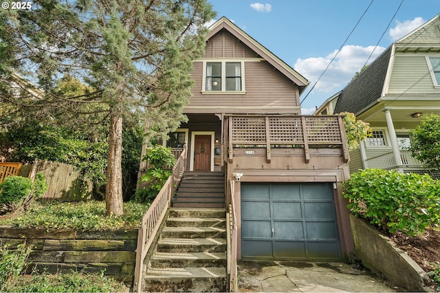 view of front of home with an attached garage, stairs, concrete driveway, fence, and covered porch