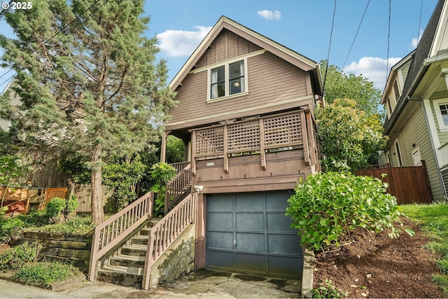 view of front of house with fence, stairs, an attached garage, and driveway