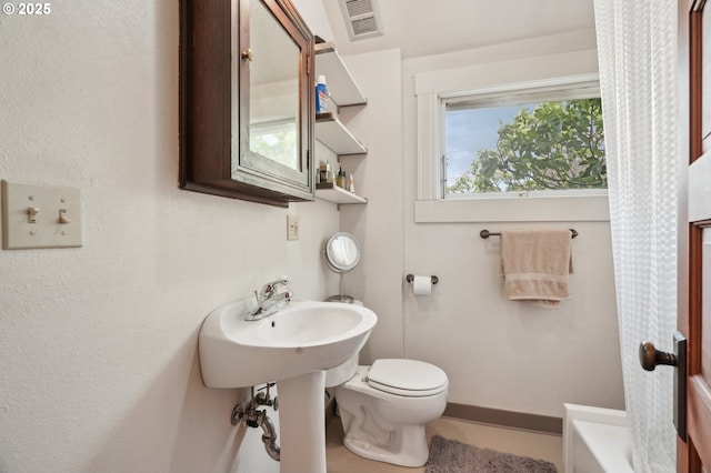 bathroom with toilet and baseboards