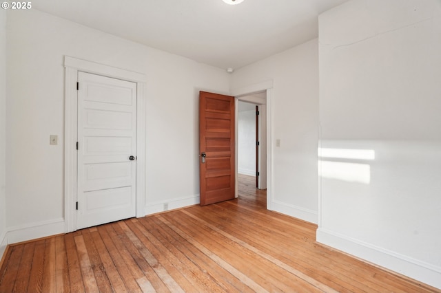 unfurnished bedroom featuring light wood-style flooring and baseboards