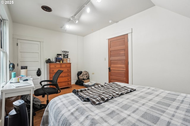 bedroom featuring wood finished floors and rail lighting