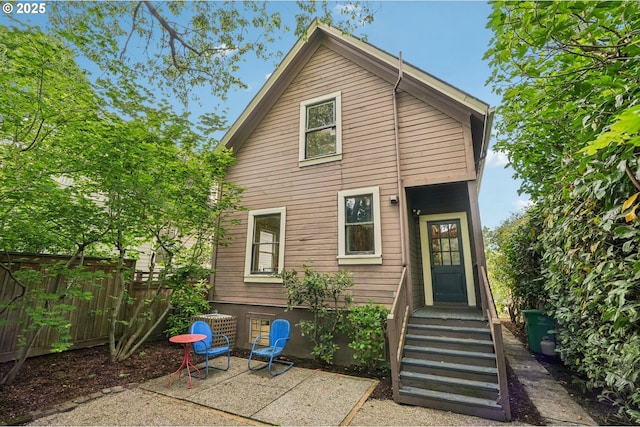 back of property with fence and a patio