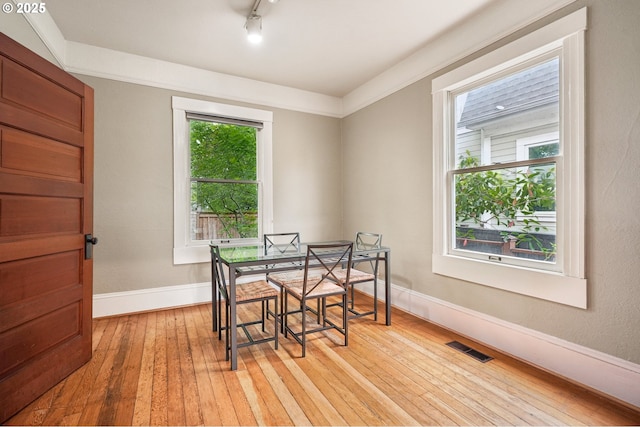dining space with light wood finished floors and baseboards
