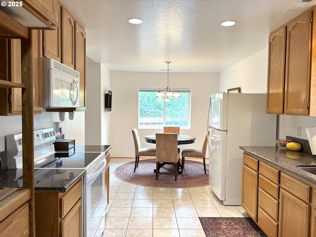 17239 Lumberview Rd, Brookings, OR 97415 - kitchen featuring white appliances, brown cabinetry, a chandelier, decorative light fixtures, and light tile patterned floors