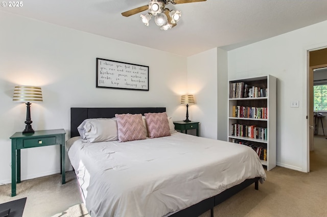 bedroom featuring ceiling fan, baseboards, and light colored carpet