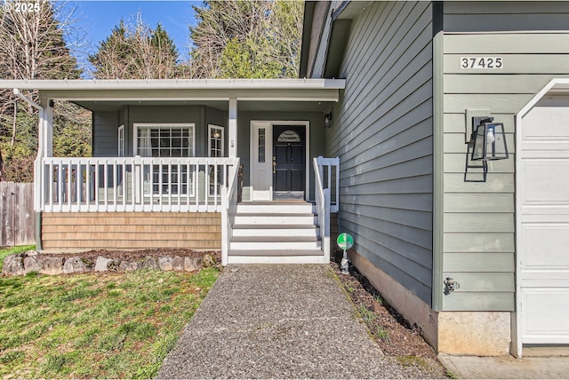 doorway to property with a garage and covered porch