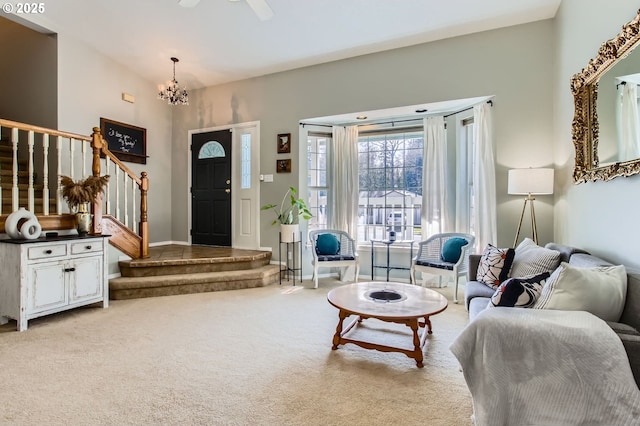 carpeted living room with baseboards, stairway, and a chandelier