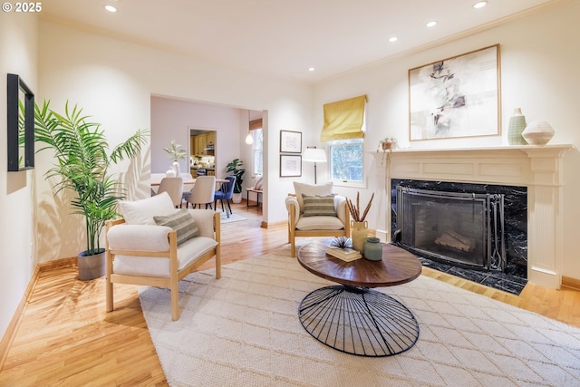 living room with wood finished floors, a fireplace, and crown molding