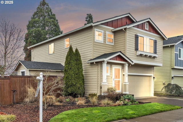 craftsman inspired home featuring a garage, aphalt driveway, board and batten siding, and fence