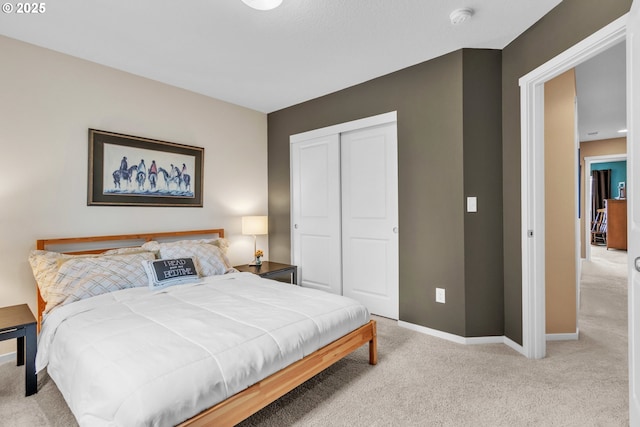 bedroom with a closet, carpet flooring, and baseboards