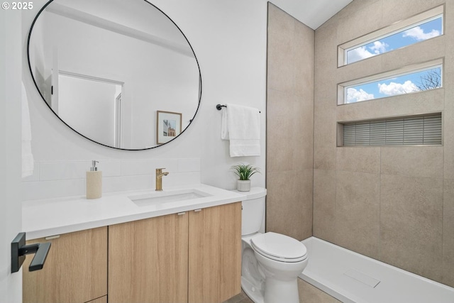 bathroom featuring decorative backsplash, vanity, and toilet