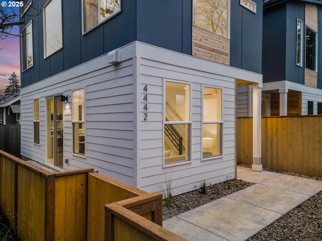 view of side of property featuring fence and board and batten siding