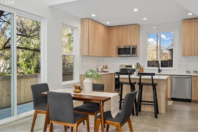 dining room featuring concrete floors, a wealth of natural light, and recessed lighting