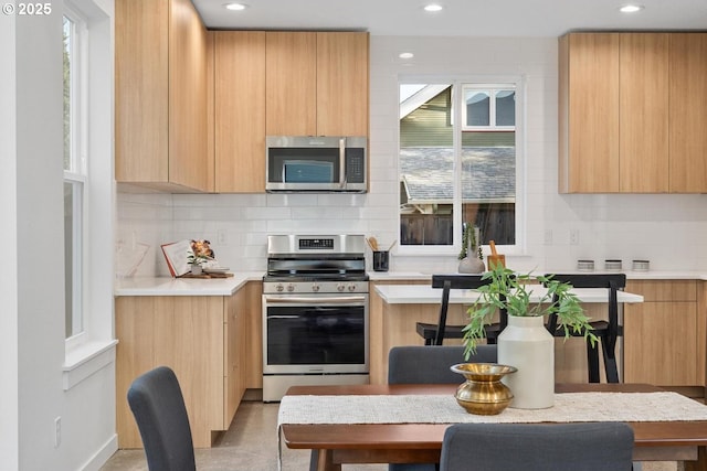 kitchen with stainless steel appliances, modern cabinets, and light brown cabinets