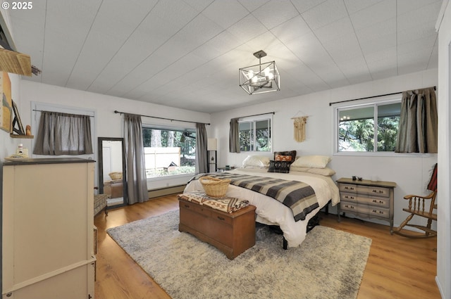 91760 Horse Creek Rd, Mckenzie Bridge, OR 97413 - bedroom with multiple windows, light wood-type flooring, and a chandelier