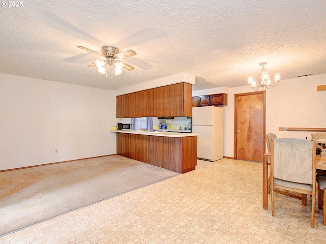 15204 NE 42nd St, Vancouver, WA 98682 - kitchen featuring freestanding refrigerator, a peninsula, brown cabinetry, ceiling fan, and a chandelier