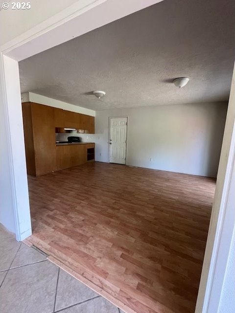 73927 Alder Grove Rd, Clatskanie, OR 97016 - unfurnished living room featuring light wood-style flooring and a textured ceiling