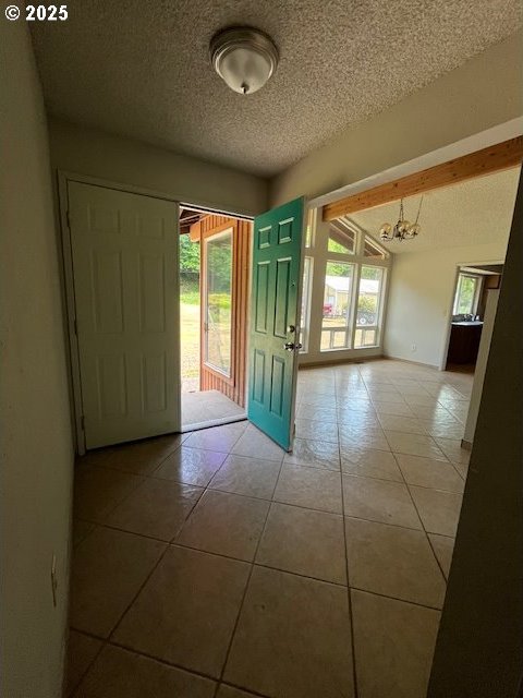 73927 Alder Grove Rd, Clatskanie, OR 97016 - tiled foyer entrance featuring a chandelier and a textured ceiling