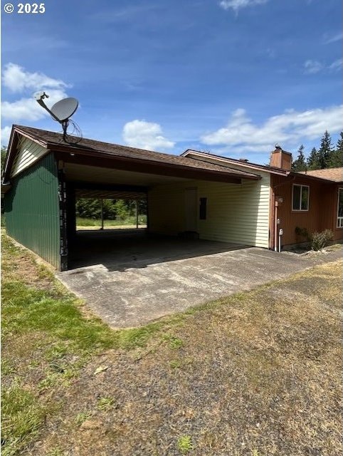 73927 Alder Grove Rd, Clatskanie, OR 97016 - view of home's exterior featuring an attached carport, driveway, and a chimney