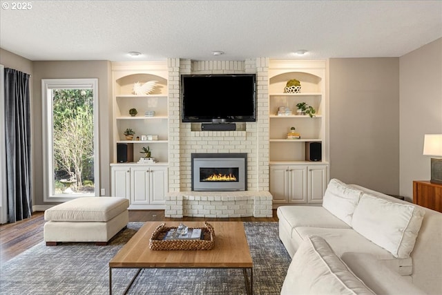 4679 Dogwood Dr, Lake Oswego, OR 97035 - living room featuring wood finished floors, a textured ceiling, built in shelves, and a brick fireplace