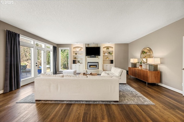 4679 Dogwood Dr, Lake Oswego, OR 97035 - living room featuring a textured ceiling, a fireplace, dark wood-type flooring, baseboards, and built in shelves