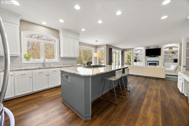 4679 Dogwood Dr, Lake Oswego, OR 97035 - kitchen with a sink, a textured ceiling, a kitchen island, white cabinets, and light stone countertops