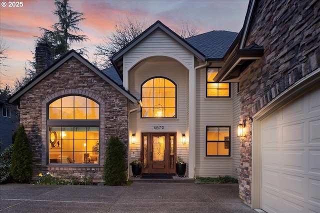 4679 Dogwood Dr, Lake Oswego, OR 97035 - property entrance featuring stone siding, a chimney, a shingled roof, and concrete driveway