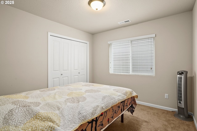 bedroom with carpet floors, baseboards, visible vents, and a closet