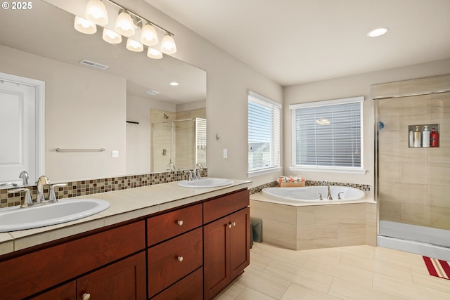 bathroom with double vanity, a sink, a bath, and a stall shower