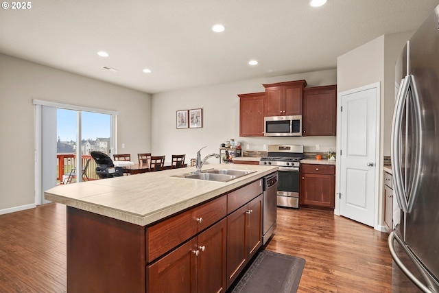 kitchen with a sink, appliances with stainless steel finishes, recessed lighting, and dark wood-type flooring