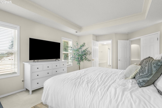 3852 Fairhaven Dr, West Linn, OR 97068 - bedroom featuring a tray ceiling, light colored carpet, and ensuite bathroom