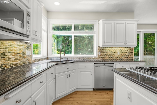 3852 Fairhaven Dr, West Linn, OR 97068 - kitchen featuring appliances with stainless steel finishes, decorative backsplash, white cabinetry, dark stone countertops, and recessed lighting