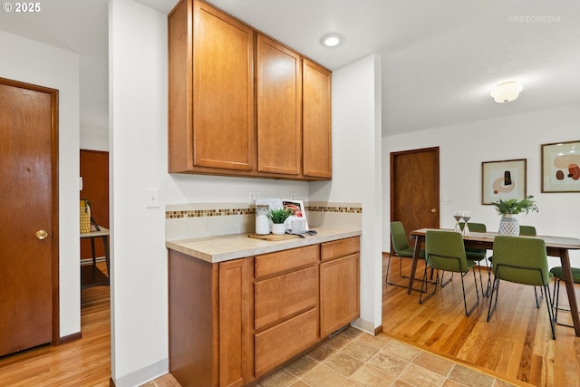 13140 SW Edgewood St, Portland, OR 97225 - kitchen featuring light countertops, light wood-type flooring, and brown cabinets