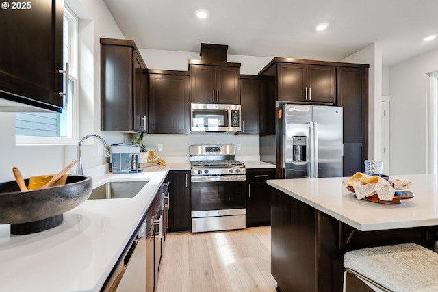 966 Legacy Ln, Eugene, OR 97402 - kitchen featuring stainless steel appliances, recessed lighting, dark brown cabinets, a kitchen bar, and light countertops