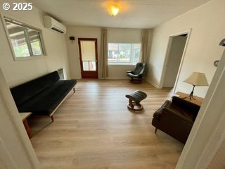313 Taylor St, Ryderwood, WA 98581 - sitting room featuring a wall unit AC and wood finished floors