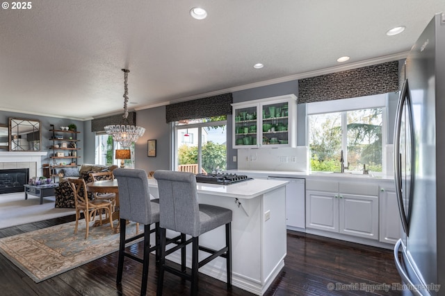 kitchen featuring sink, stainless steel fridge, a center island, white dishwasher, and white cabinets