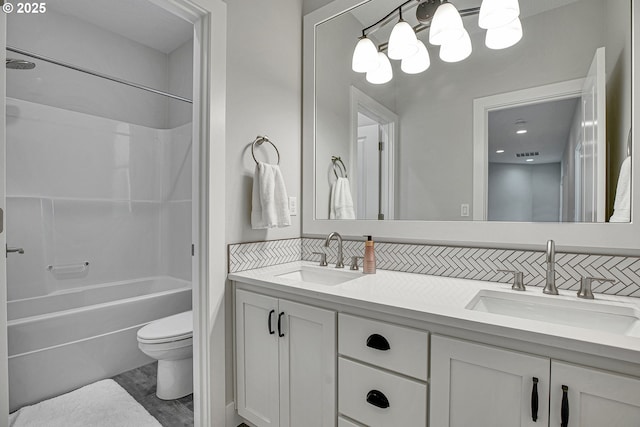 full bathroom with a sink, toilet, double vanity, and visible vents