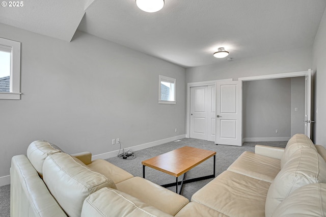 living room with a textured ceiling, baseboards, and carpet