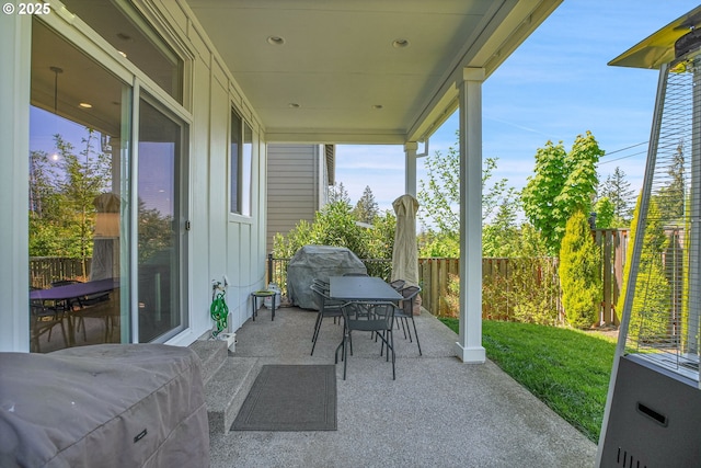 view of patio with outdoor dining area, a fenced backyard, and a grill