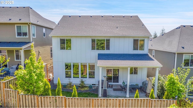 back of house featuring a fenced backyard, a patio, board and batten siding, and a shingled roof