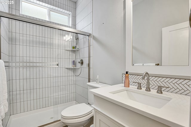 bathroom with vanity, backsplash, a stall shower, and toilet