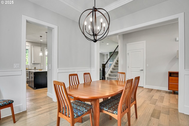 dining space featuring a chandelier, stairway, and light wood-style floors