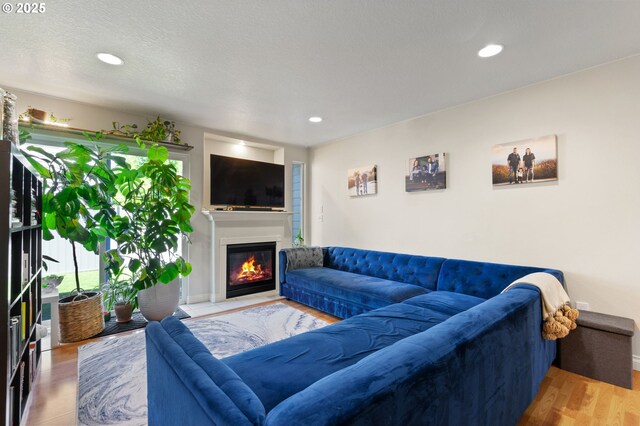 17881 SW Pars Pl, Beaverton, OR 97078 - living room featuring a glass covered fireplace, wood finished floors, and recessed lighting