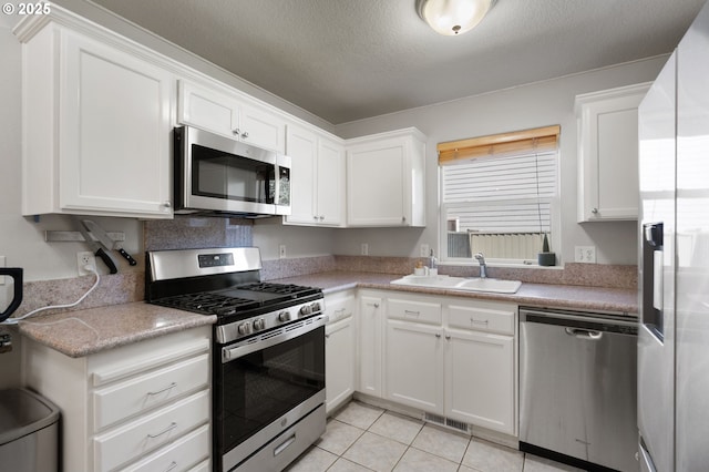 17881 SW Pars Pl, Beaverton, OR 97078 - kitchen featuring stainless steel appliances, a sink, white cabinets, light countertops, and light tile patterned flooring
