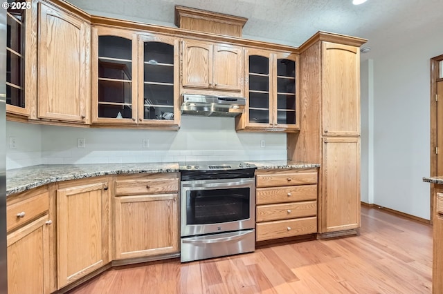 4202 SE 31st St, Gresham, OR 97080 - kitchen featuring electric range, under cabinet range hood, light wood-style flooring, glass insert cabinets, and light stone counters