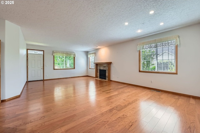 4202 SE 31st St, Gresham, OR 97080 - unfurnished living room featuring a textured ceiling, wood finished floors, baseboards, a tile fireplace, and recessed lighting