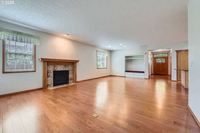 4202 SE 31st St, Gresham, OR 97080 - unfurnished living room with a textured ceiling, light wood-style floors, a high end fireplace, and baseboards