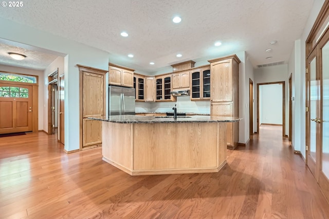 4202 SE 31st St, Gresham, OR 97080 - kitchen featuring freestanding refrigerator, an island with sink, a textured ceiling, baseboards, and light wood-style floors