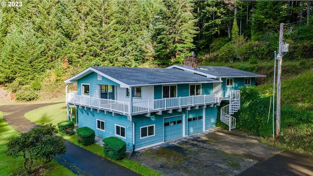 rear view of property featuring a lawn, a balcony, and a garage